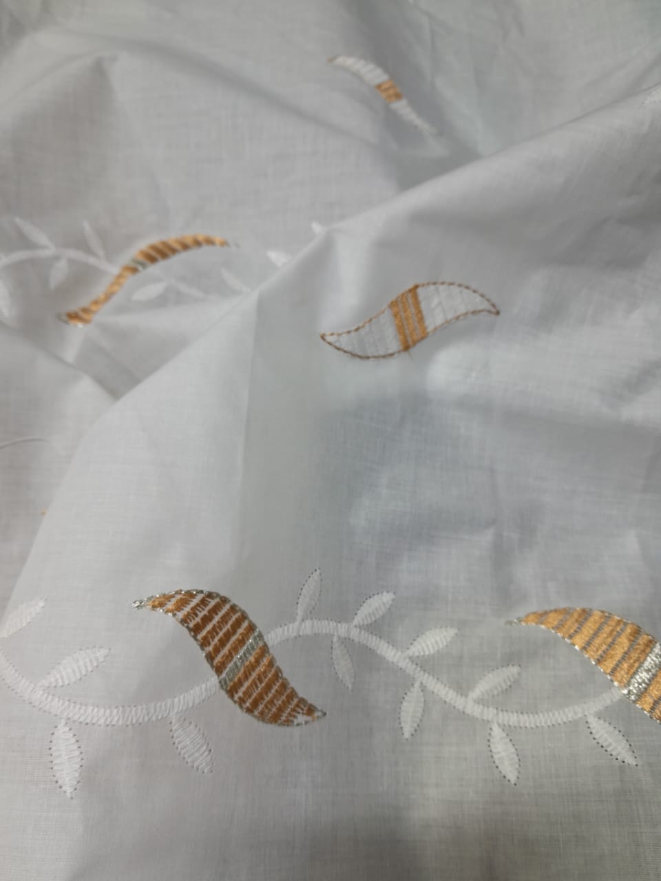 White Cotton Chikan Embroidery Fabric with Golden Leaf Motif Product Description: